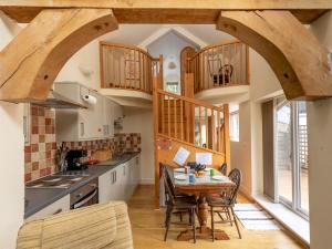 a kitchen with a table and chairs in a room at Pass the Keys A unique and cosy cottage - optional hot tub in Church Stretton