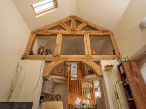 a room with a large wooden ceiling in a house at Pass the Keys A unique and cosy cottage - optional hot tub in Church Stretton