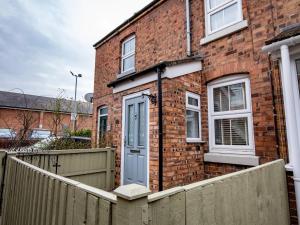 een stenen huis met een blauwe deur en een hek bij Pass the Keys Central cosy home 5 minutes walk from Shrewsbury in Shrewsbury