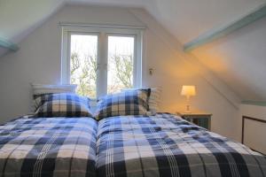 een slaapkamer met een bed en een raam bij Eb in Callantsoog