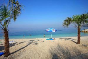 een strand met een parasol en mensen in het water bij Adriatic Deluxe in Dugi Rat