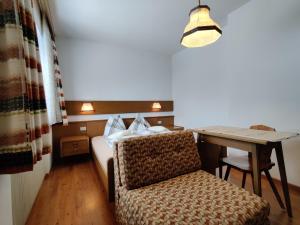 a bedroom with a bed and a desk and a table at Lärchenheim in Obereggen