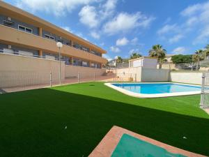 a building with a pool and a green lawn at Apartamentos Playamar in Isla Plana