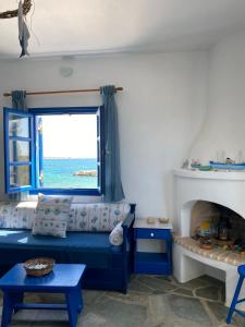 a living room with a blue couch and a window at Cavos Studio by the sea in Drios