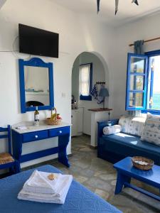 a blue and white room with a bed and a table at Cavos Studio by the sea in Drios