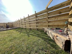a wooden fence with a garden in a yard at Taigh Neonach in Watten