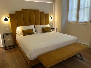 um quarto com uma grande cama branca e uma cabeceira em madeira em Corte dei Sogni Boutique Hotel & spa em Florença