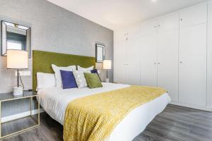 um quarto com uma cama grande e um cobertor amarelo em Precioso Ático de diseño, gran Terraza y Garaje en pleno centro em Sevilha