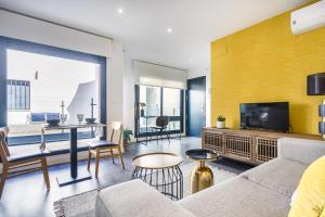 uma sala de estar com um sofá e uma televisão em Precioso Ático de diseño, gran Terraza y Garaje en pleno centro em Sevilha
