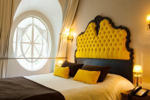 a bedroom with a large bed with a yellow headboard at Rendez Vous Hotel Buenos Aires in Buenos Aires
