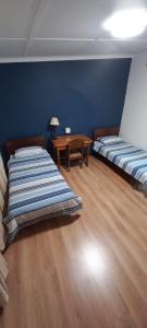 um quarto com duas camas e uma mesa em Guesthouse 914 em Sabie