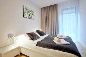 Łóżko lub łóżka w pokoju w obiekcie OnHoliday Apartamenty ze strefą Relax & Fun, ul Lwowska 12