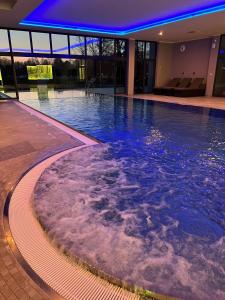 uma grande piscina com luzes azuis num edifício em Landhotel Burg im Spreewald - Resort & Spa em Burg