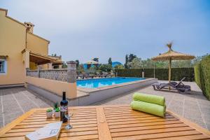 a patio with a table and an umbrella and a pool at Can Pansa in Port de Pollensa