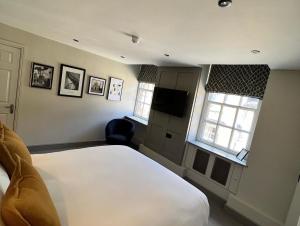 a bedroom with a white bed and two windows at The Punchbowl Inn in Woodstock