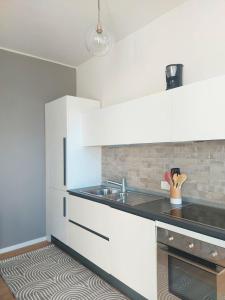 een keuken met witte kasten en een spoelbak bij Bellavista Lago Maggiore in Cerro Lago Maggiore