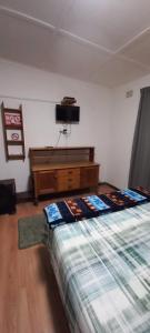 um quarto com uma cama e uma televisão na parede em Guesthouse 914 em Sabie
