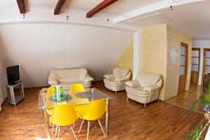 sala de estar con sillas amarillas y mesa de cristal en Lux Condo, en Krynica-Zdrój