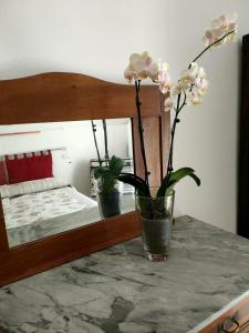 una mesa con un jarrón con flores. en La Rosa appartamenti, en Monterchi