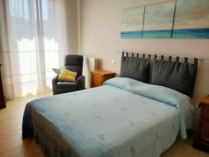 1 dormitorio con 1 cama y 1 silla en La Rosa appartamenti, en Monterchi
