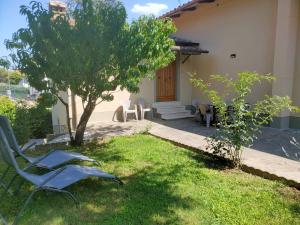 un patio con sillas, un árbol y una casa en La Rosa appartamenti, en Monterchi