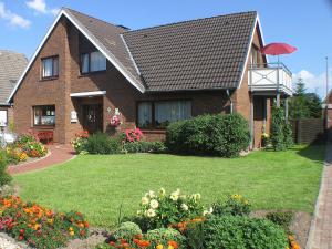 ein Haus mit einem Garten mit Blumen davor in der Unterkunft Haus Elke Wohnung 103 in Büsum