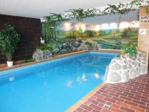 een groot blauw zwembad met een schilderij aan de muur bij Landhaus Sauerlandblick in Bestwig