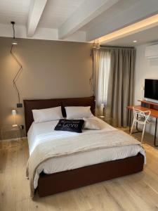 トッリ・デル・ベーナコにあるSuite Agli Archiの大きなベッドとテレビのある寝室