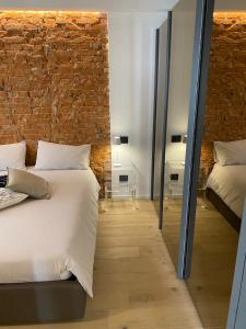 a bedroom with a white bed and a brick wall at Suite Agli Archi in Torri del Benaco +53 photos