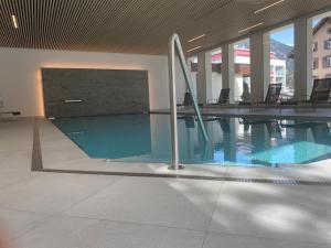 a large swimming pool in a building with chairs at Davos, Residenz Meierhof, Chasa Hubertus in Davos