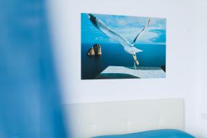 a white bird flying over the ocean with a picture at Capri holiday home with a sea view in Capri