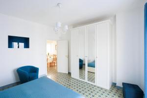 a bedroom with a blue bed and a mirror at Capri holiday home with a sea view in Capri
