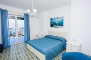 a bedroom with a blue bed and a balcony at Capri holiday home with a sea view in Capri