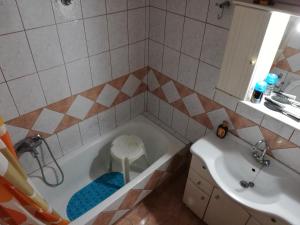 a bathroom with a tub and a sink and a stool at APARTMENT MARIOS SOUFLI Ευρύχωρη γκαρσονιέρα, 60m2 στο κέντρο in Souflíon +6 photos