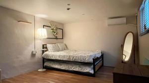 Dormitorio pequeño con cama y espejo en SISnBRO Guesthouse, en Seúl