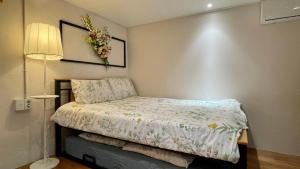 Un dormitorio con una cama con un arreglo floral en la pared en SISnBRO Guesthouse, en Seúl