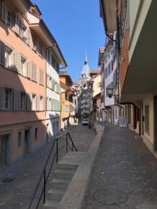 an empty street in a city with buildings at Casa Koraal - Old Town Zug in Zug