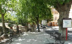 un parque con bancos y árboles y un cartel en Valle del Genil, en Pinos Genil