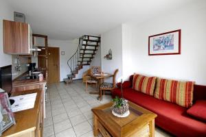 een woonkamer met een rode bank en een keuken bij Landhaus Sauerlandblick in Bestwig