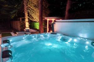a hot tub in a backyard at night at Pink Spa Nest in Blairgowrie