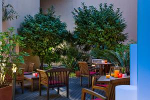 un patio avec des tables, des chaises et des arbres dans l'établissement Citadines Croisette Cannes, à Cannes