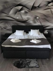 una camera da letto con un letto con due asciugamani sopra di Brill Hotel Békéscsaba a Békéscsaba Altre 18 foto