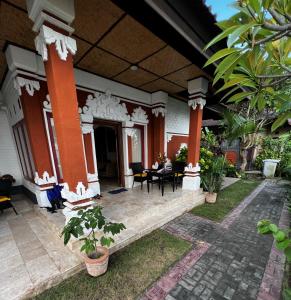 una casa con columnas de naranja y un patio en Villa Mola Mola en Candidasa