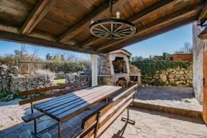 drewnianym patio ze stołem i kominkiem w obiekcie Guest House Risika w mieście Vrbnik