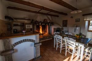 kuchnia z kominkiem, stołem i krzesłami w obiekcie Guest House Risika w mieście Vrbnik