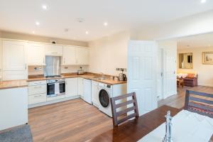 a kitchen with white cabinets and a dining room at Pink Spa Nest in Blairgowrie