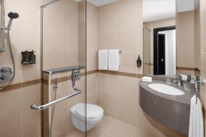 
a bathroom with a toilet, sink, and shower stall at Holiday Inn Express Dubai Safa Park, an IHG Hotel in Dubai
