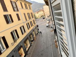 uitzicht op een straat vanuit een raam van een gebouw bij Casa la Breva in Lecco