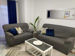 a living room with two couches and a coffee table at Apartamento Amplio 6 plazas junto al Centro in Málaga