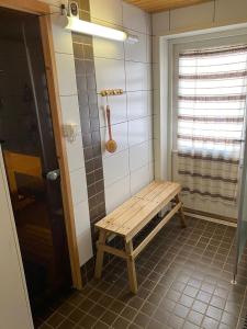 baño con banco de madera en una habitación en Huoneisto Äkäsjokisuu - Lapin Linna en Äkäsjoensuu